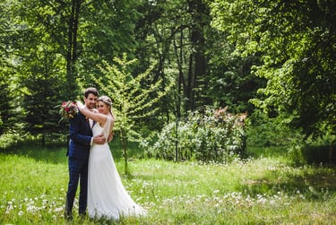 Bride and groom standing in a forest.