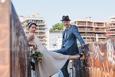 Bride and groom photographed between walls covered in graffiti.
