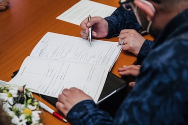 Grooms signing wedding documents.