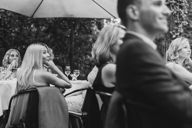 Wedding guests sitting at tables and listening to a speech.