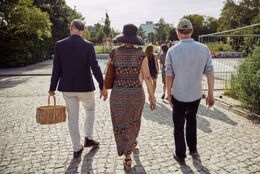 Three wedding guests walking on a cobbled path in Mauerpark.