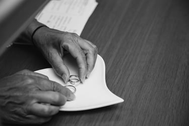 Woman placing wedding rings on a plate shaped like a heart.