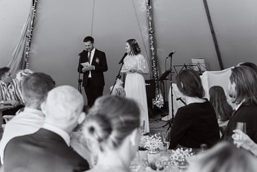 Wedding couple doing speeches in a tent.