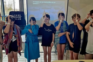 9 enfants qui font le signe de reconnaissance du requin Aquajeunes Massy