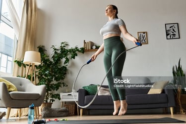 a woman in a sports bra and leggings is doing a jump