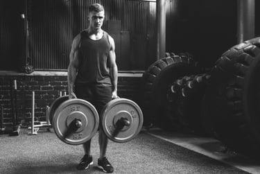 Muscular man performing farmer's walk with heavy weights in a gritty cross-training gym.
