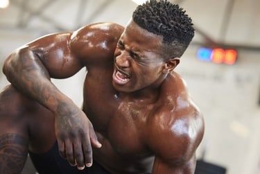 Sweaty muscular athlete resting after an intense bodybuilding workout in the gym.