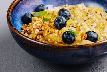 A healthy breakfast bowl with quinoa, fresh blueberries, and crunchy granola topping.