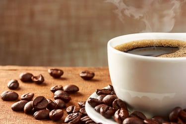 a cup of coffee and some beans on a table