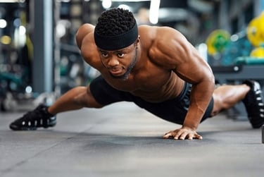 Muscular man performing intense wide-arm pushups during a fitness workout in a modern gym.
