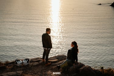 a couple of people standing on a rock