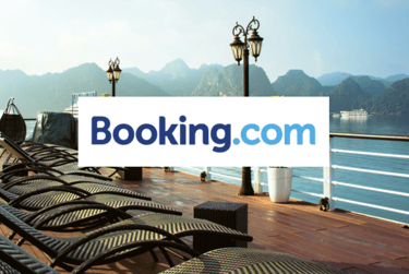 Booking.com Logo with image of a cruise lounging area in the background /