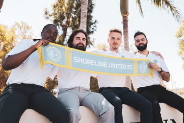 a group of men sitting on a bench with a scarf around their necks
