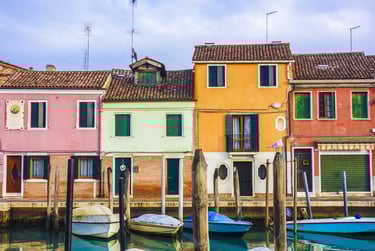 Imagen de casas coloridas en Italia frente a un canal.