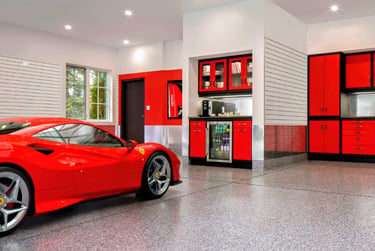Luxury garage with a red Ferrari, epoxy flooring, and custom red storage cabinets.