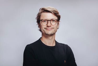 Young man in a black t-shirt photographed in a studio.