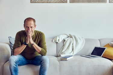 Tim Nidernolte sitzt in einem grünen Pullover auf einem Sofa.