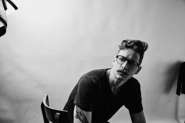 Ein Mann sitzt auf einem Stuhl in einem Fotostudio.