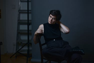 A studio portrait of a German female writer sitting on a chair.