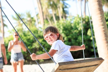 Child playing on wooden swing during Koh Samui family photoshoot