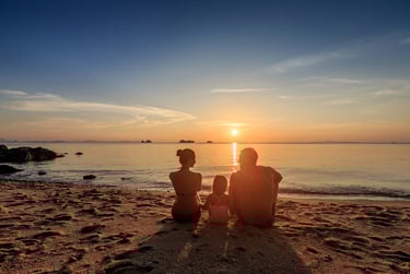 Family sitting together on beach at sunset during Koh Samui photoshoot