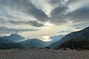 a person sitting on a bench in the mountains
