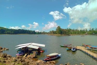Dermaga perahu wisata di tepi Situ Cileunca dengan perahu-perahu berwarna-warni yang bersandar di bawah langit biru cerah