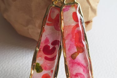 a pair of earrings with a pink flower