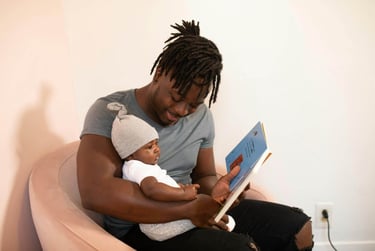 A young father reading a children's picture book to a child.