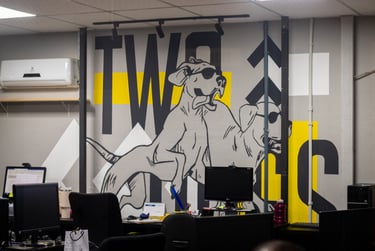 a dog sitting on a desk with a computer monitor