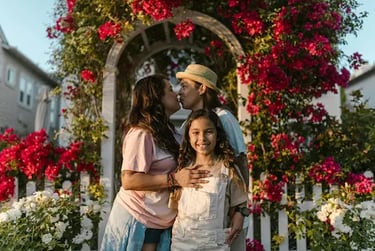 young latin family with girl child in a rose garden at sunset