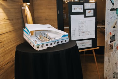 Gala photos showcasing model of a future building plan and blueprints