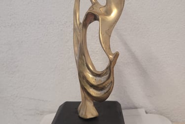 a bronze sculpture of a woman holding a flower