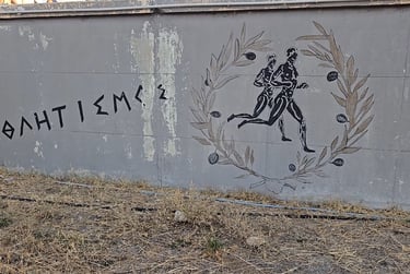 Greek mural depicting runners in an olive wreath with the word athletics written in Greek.