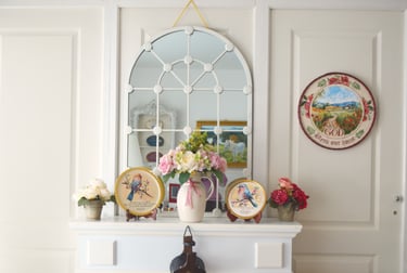a vase with flowers on a mantle