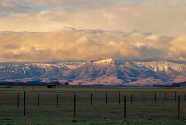 a large mountain range with a fenced in area, located in Montana, Teton Mountain Range
