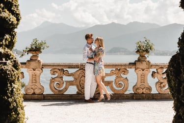a couple kissing on a balcony overlooking the water at Villa Balbianello