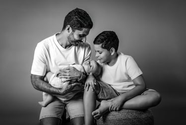 "Un retrato de familia en blanco y negro, padre con su hijo mayor y bebé en brazos"