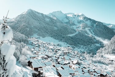 a snowy mountain scene with a view of a village