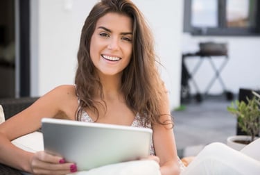 a woman sitting on a couch with a tablet computer