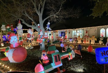 a house with christmas lights and holiday decorations on display