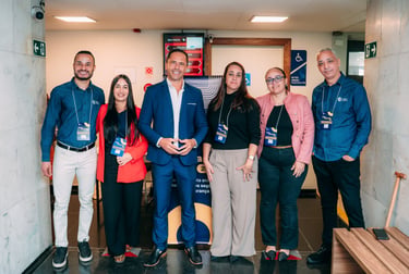 Group of business professionals posing at a corporate event seminar in a hallway.