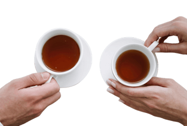 A top-down view of two people holding white ceramic cups of hot black tea over saucers.