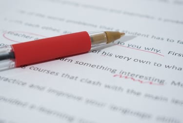 an essay being graded with red pen