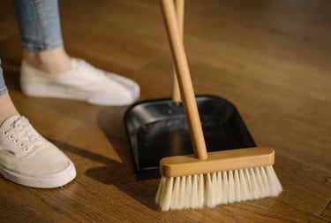 a person standing on a wooden floor with a broom and a broom