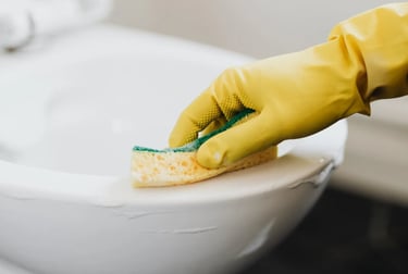 a person in yellow gloves cleaning a toilet
