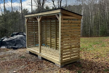 a chord of chopped wood logs stacked on top of each other in a wooden storage shed