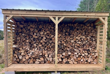 a chord of chopped wood logs stacked on top of each other in a wooden storage shed