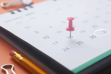 A calendar with a pushpin marking a particular day.