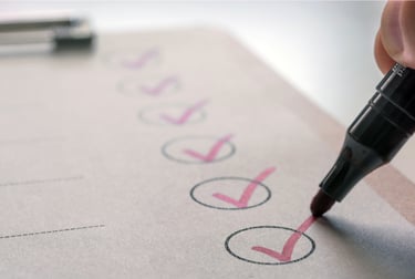 A photo of a checklist and marker showing red checkmarks in each circle of the list 